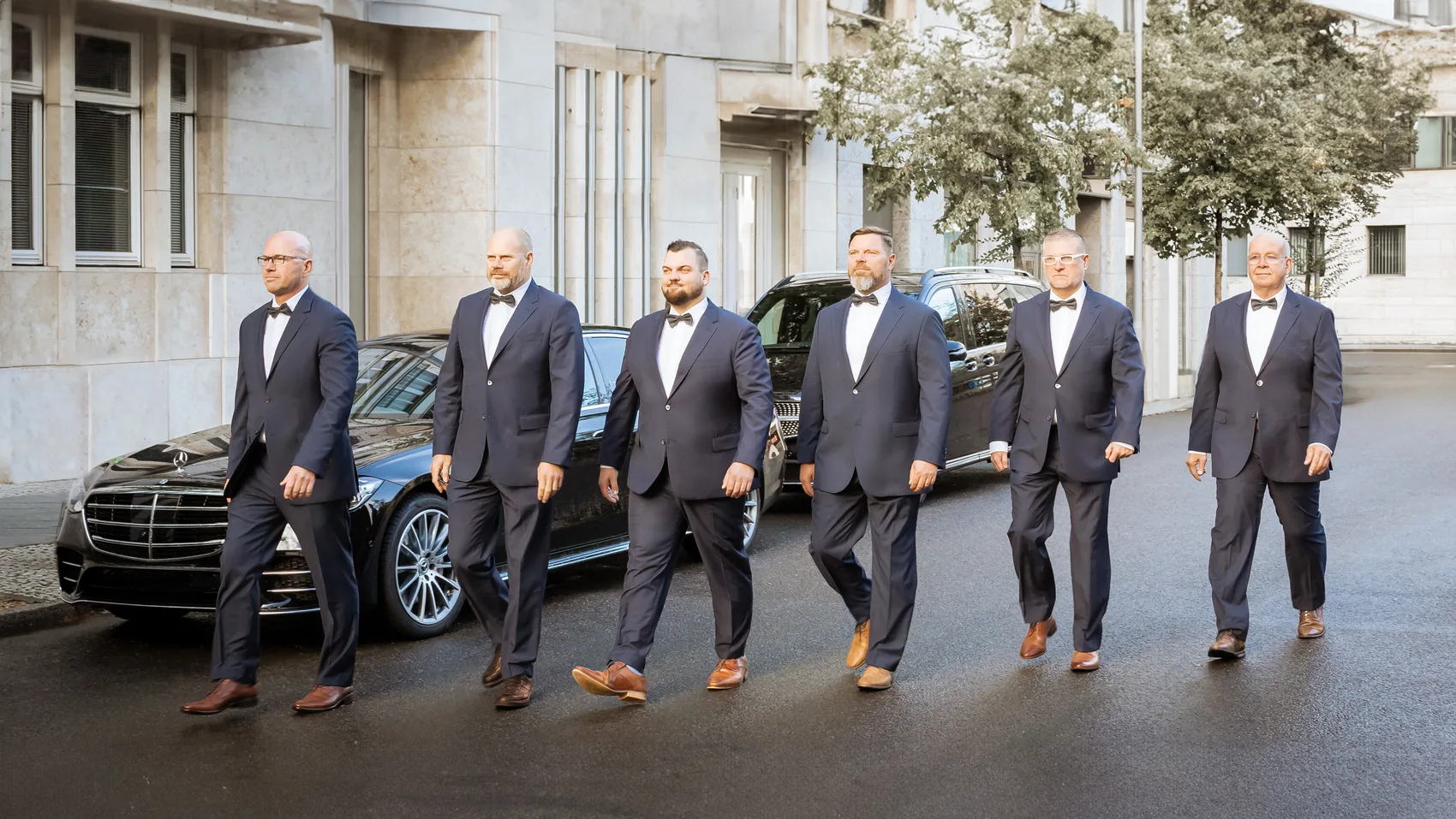 Das Chauffeur-Team der Agentur Maximal vor einer Limousine